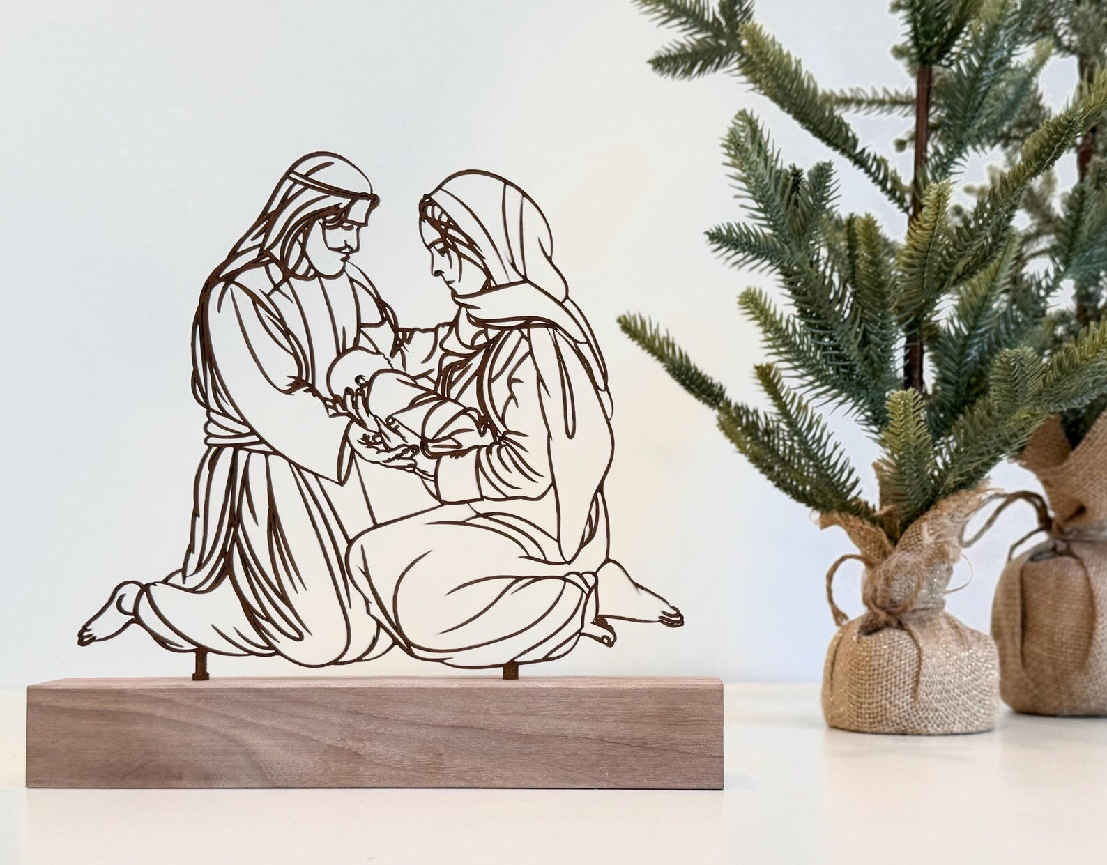 Decorative cutout of a religious scene with a tree in the background