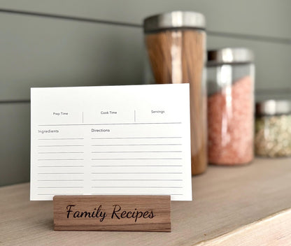 Recipe card on a wooden stand with 'Family Recipes' text, placed on a surface with jars in the background.