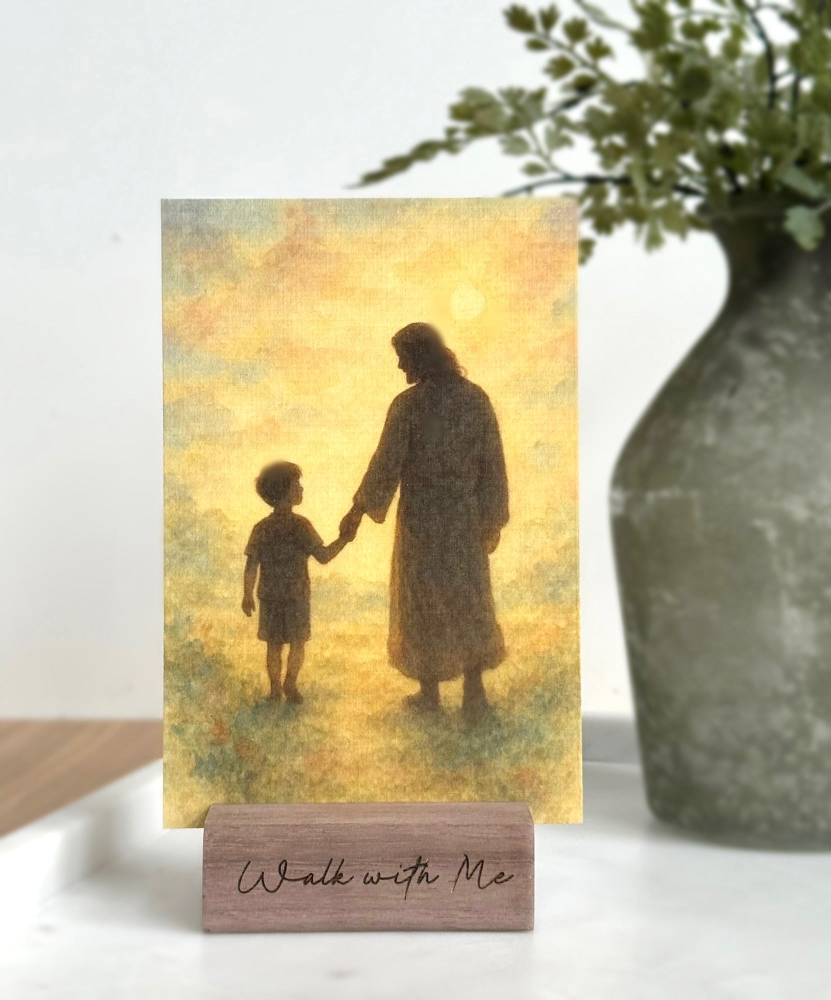 Silhouette of a man and child holding hands with 'Walk with Me' sign on wooden stand.